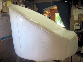 Round modern style white chair upholstered with faux leather